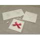 Wedding card in mulberry paper with red satin bow with polka dots